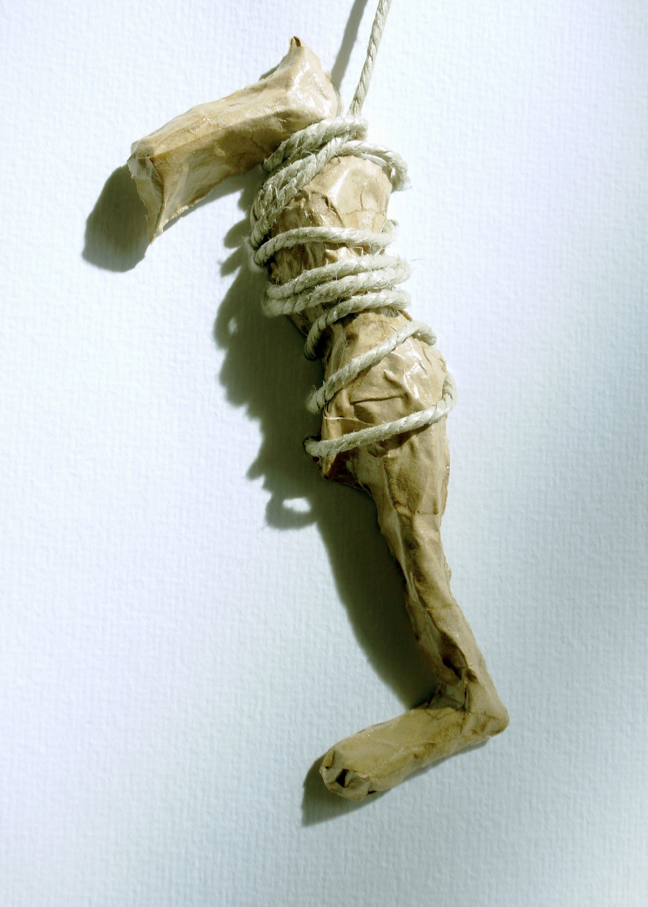 Abstrakte Papierfigur mit Seilumwicklung, hängend