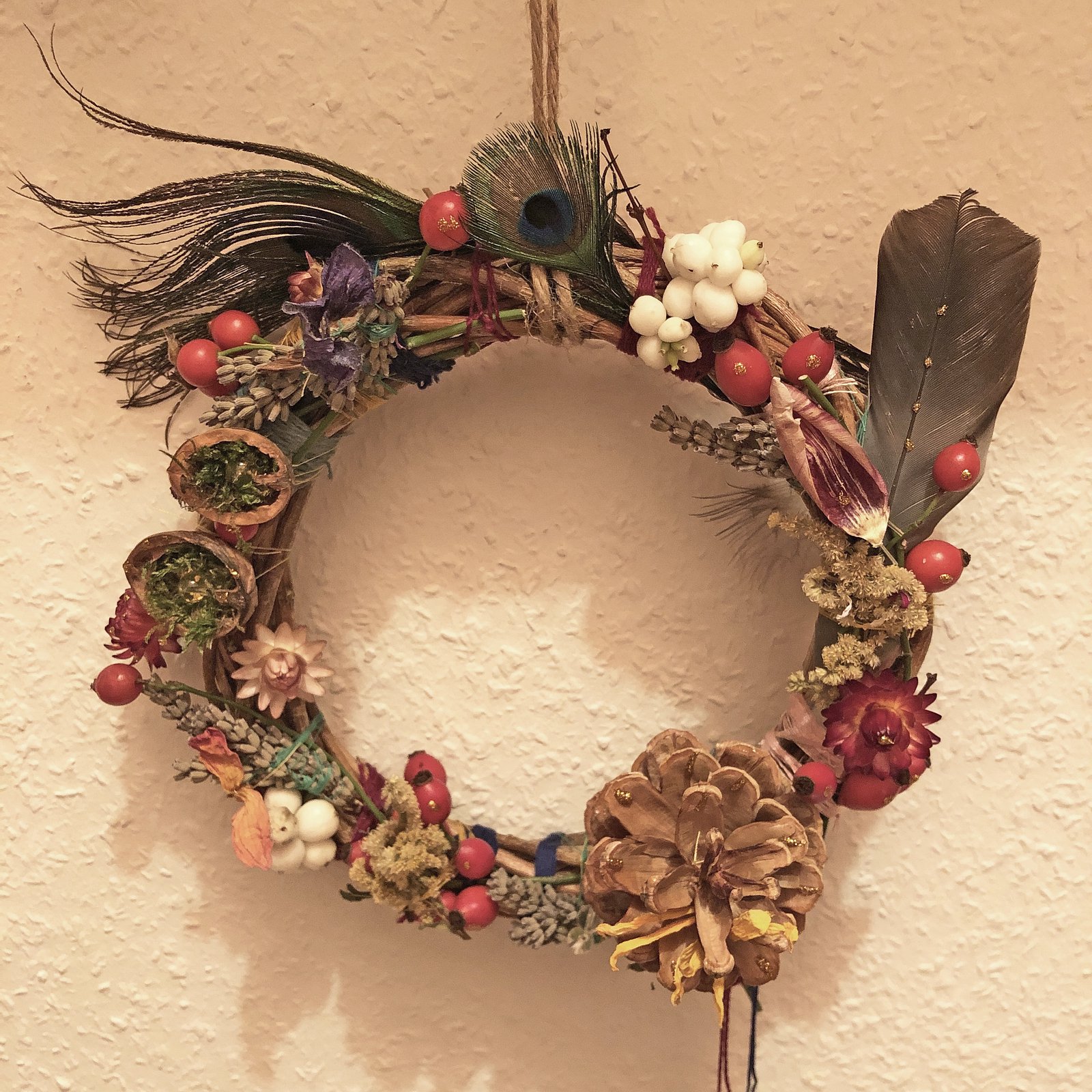 Naturkranz aus Trockenblumen, Beeren, Zapfen und Pfauenfeder