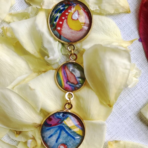 Dreifach-Anhänger mit handbemalten Glassteinen in Goldrahmen auf Blütenblättern