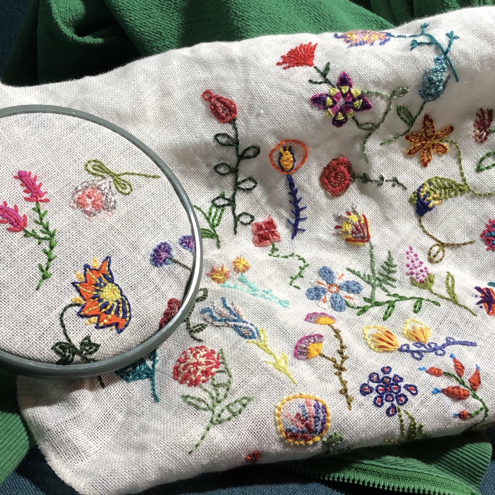 Bunte Blumenstickerei auf hellem Leinenstoff mit Stickrahmen