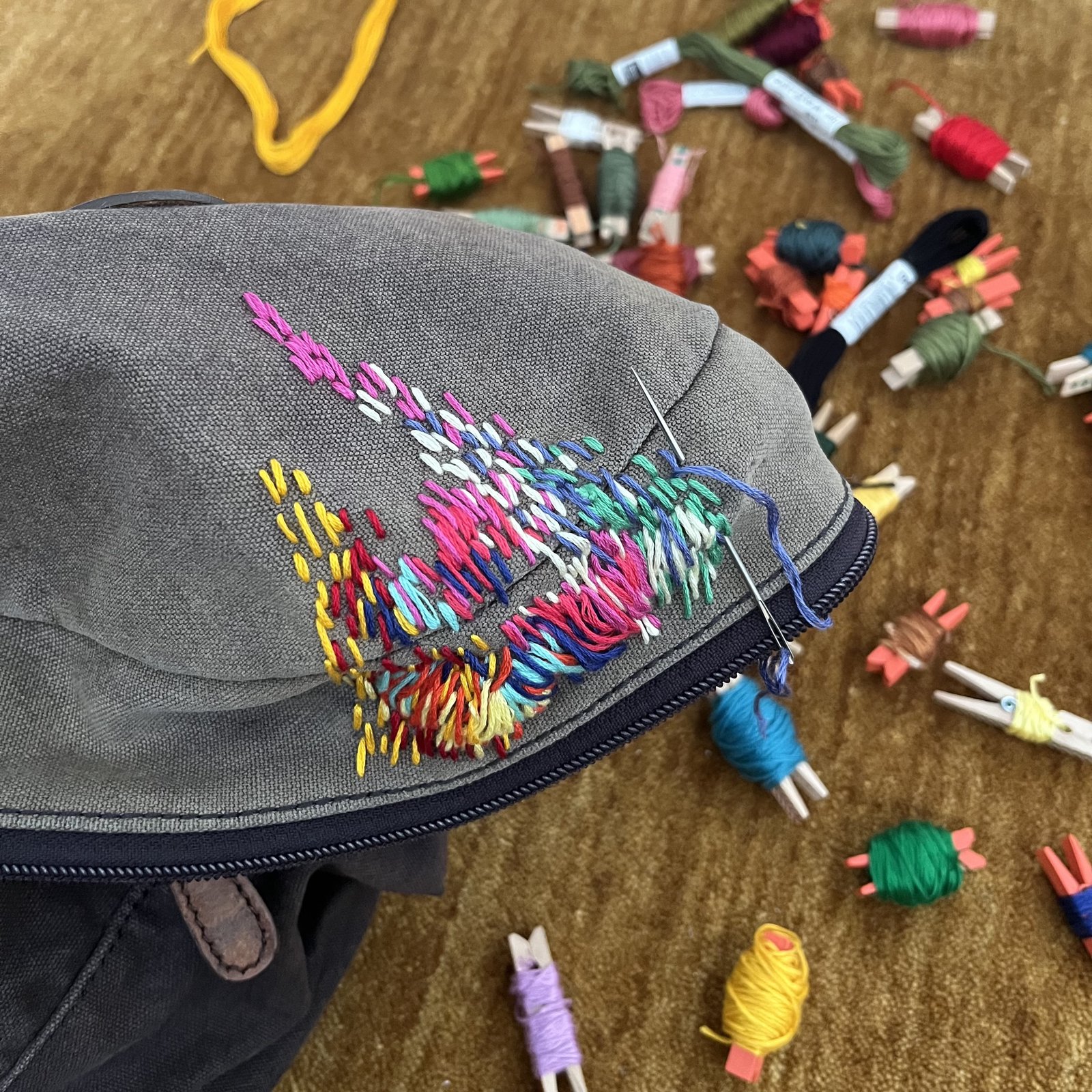 Bunt bestickte graue Gürteltasche mit Stickgarnen